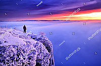 Фотообои с изображением мужчины на вершине горы зимой на закате