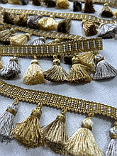 Бахрома декоративная золотисто - серого цвета.